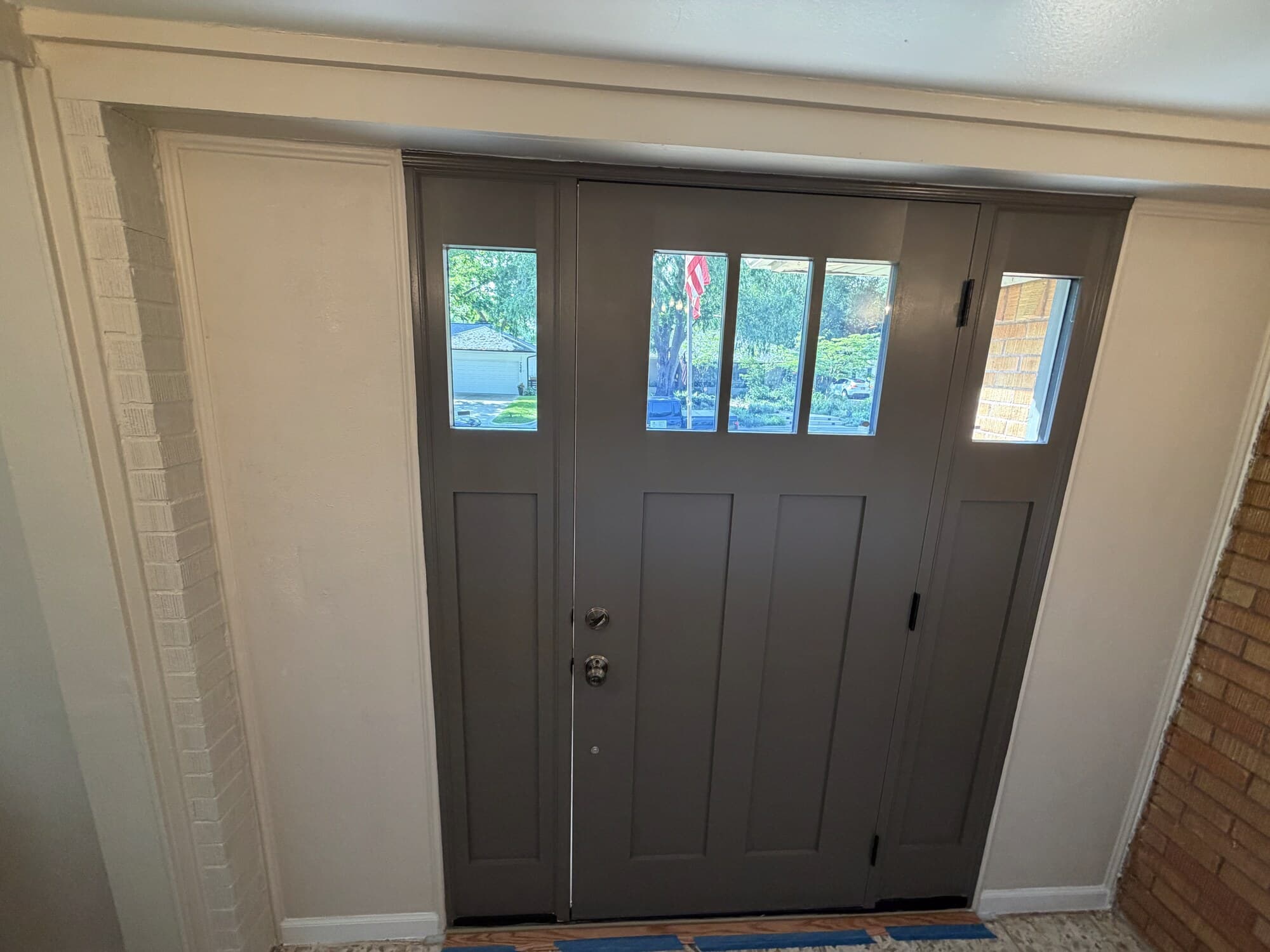 Interior view of the new front door and sidelights, dark grey finish, from the entry hall